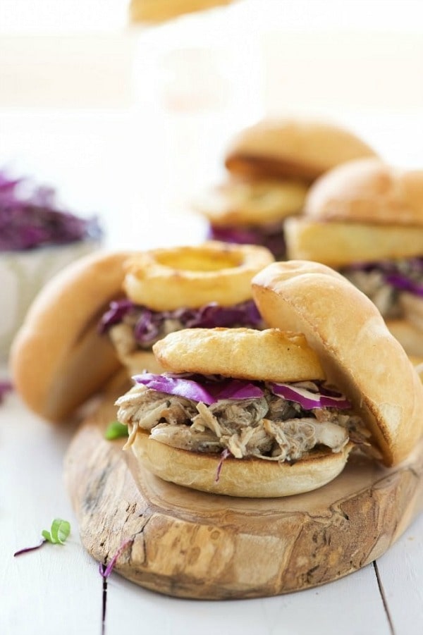 Brown Sugar Pulled Chicken Sandwiches have the most tender, slightly sweet chicken! The slow cooker makes dinner a breeze for these sliders that are topped with a tangy homemade honey mustard sauce and crispy onion rings!