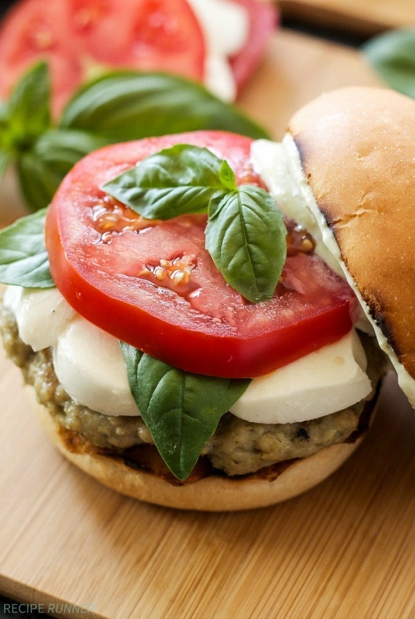 Juicy chicken burgers gone caprese style thanks to pesto, fresh basil, and thick slices of tomato and fresh mozzarella. These are a must make this summer!