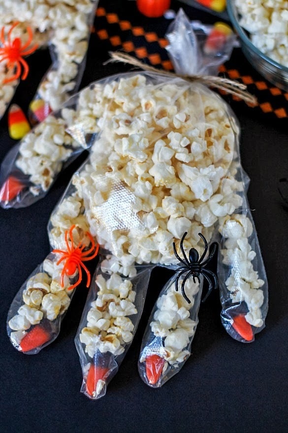 Fun Halloween craft to make with kids! Disposable gloves with candy corn fingernails, filled with popcorn. So cute!