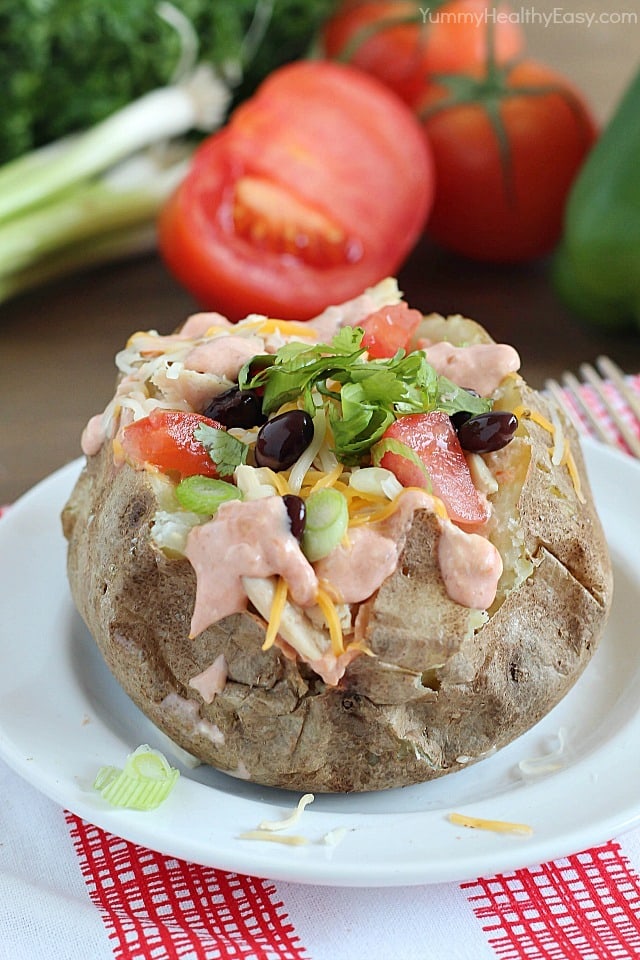 Easy Crock Pot Baked Potatoes served with a creamy salsa and topped with all your favorite taco toppings!