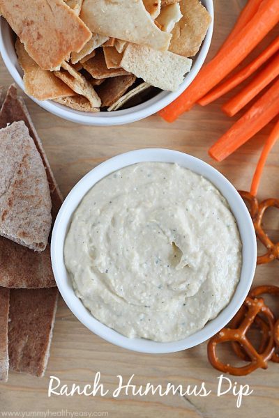 Overhead view of a bowl filled with Ranch Hummus Dip with chips and carrots surrounding it + 43 Healthy Snack Ideas