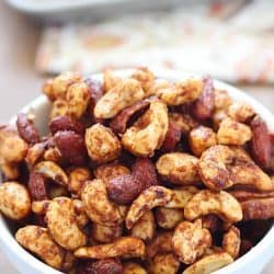 A white bowl overfilled with Healthy Spiced Nuts + 43 Healthy Snack Ideas