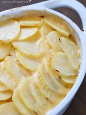 Cheesy Potatoes au Gratin made with a homemade cheese sauce drizzled over thinly sliced potatoes and a layer of onions nestled in the middle. A great Thanksgiving recipe! Plus a full blog hop Thanksgiving menu to help plan your turkey day meal!