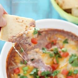 Pita chip is dipped into a cheesy Healthy Black Bean Dip + 43 Healthy Snack Ideas!