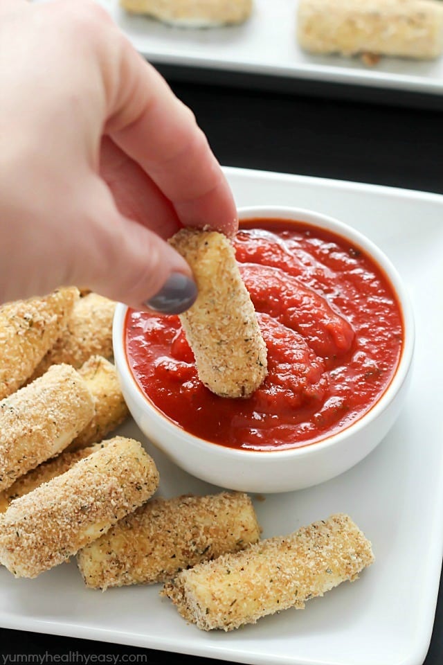 Quick and easy Baked Mozzarella Sticks for the win! A fast crowd-pleasing appetizer of warm and gooey cheese dipped in marinara sauce - yum!