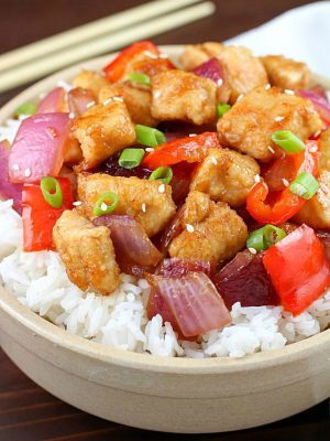 The most incredible Orange Chicken Stir Fry in a white bowl with chopsticks.