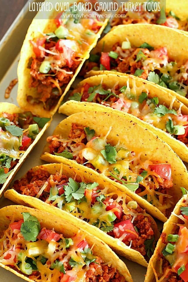 Ground Turkey Tacos that are oven-baked with layers of deliciousness inside! Refried beans, ground turkey taco meat, (no taco seasoning mix!) tomato, cilantro, green onions and cheese all baked in taco shells. Perfect for Taco Tuesday or for game day! AD