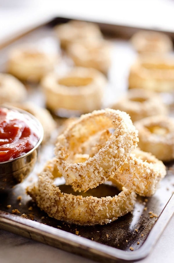 Baked Southwest Onion Rings are a lightened up version of a classic appetizer! Onions are coated in whole wheat flour, eggs, Panko bread crumbs and a mix of southwest spices and baked instead of fried for a healthy side dish.