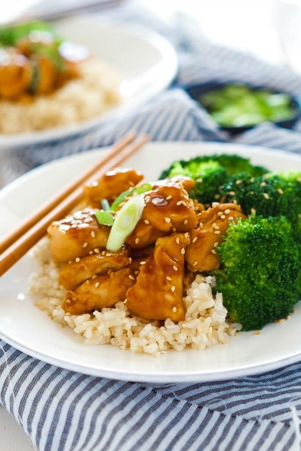 These delicious Skinny Honey Teriyaki Chicken Rice Bowls are a super quick dinner! Tender chicken is sauteed until juicy and simmered in a homemade, healthy teriyaki sauce. Served with fresh veggies and rice, you will forget all about takeout!