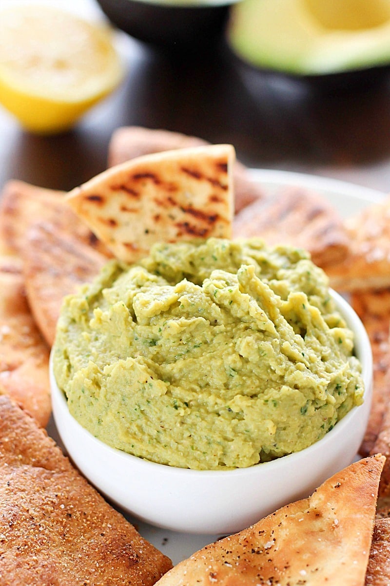Avocado Hummus with Homemade Pita Chips - you will go crazy for the combo of avocado, garbanzo beans and spices! Dip in some easy homemade pita chips, and you have yourself a healthy, flavorful snack! 
