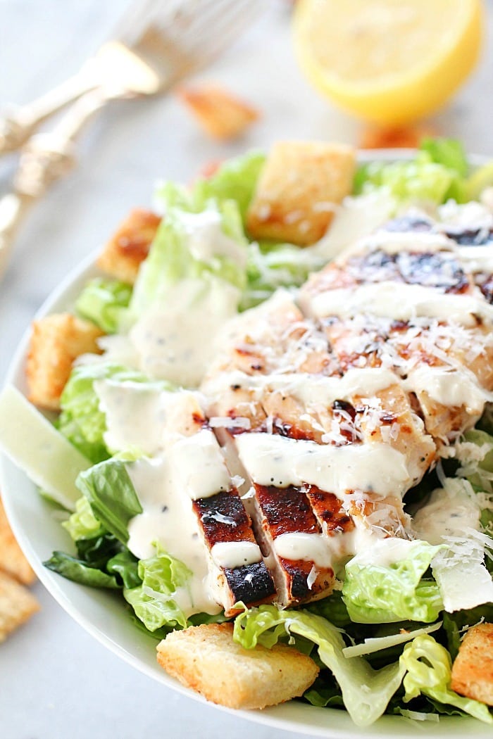 Grilled Chicken Caesar Salad for a yummy summertime lunch or dinner! With a simple yogurt marinade recipe, this grilled chicken is tender and delicious. Served over romaine lettuce, homemade croutons, shaved parmesan and caesar dressing - YUM!! AD