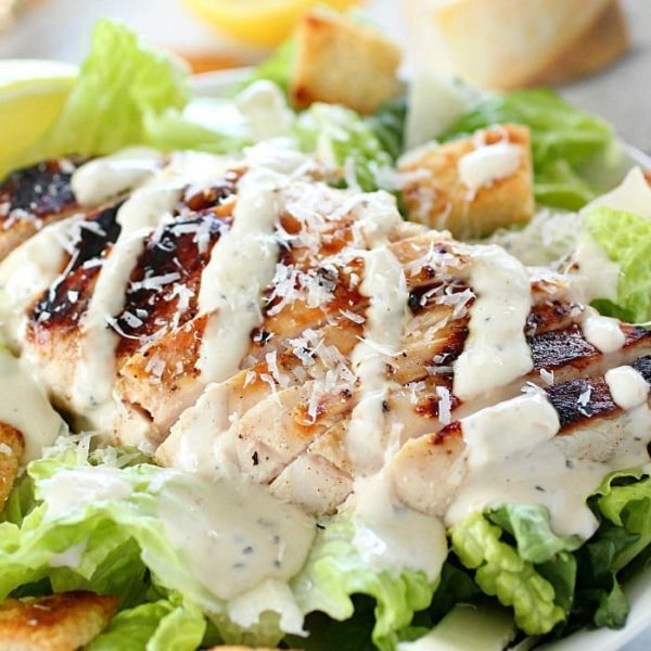 Grilled Chicken Caesar Salad for a yummy summertime lunch or dinner! With a simple yogurt marinade recipe, this grilled chicken is tender and delicious. Served over romaine lettuce, homemade croutons, shaved parmesan and caesar dressing - YUM!!