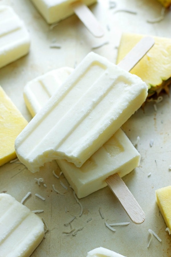 These Coconut Pineapple Yogurt Pops are a tropical vacation on a stick! Creamy, fruity, sweet and cold - the perfect summertime treat!