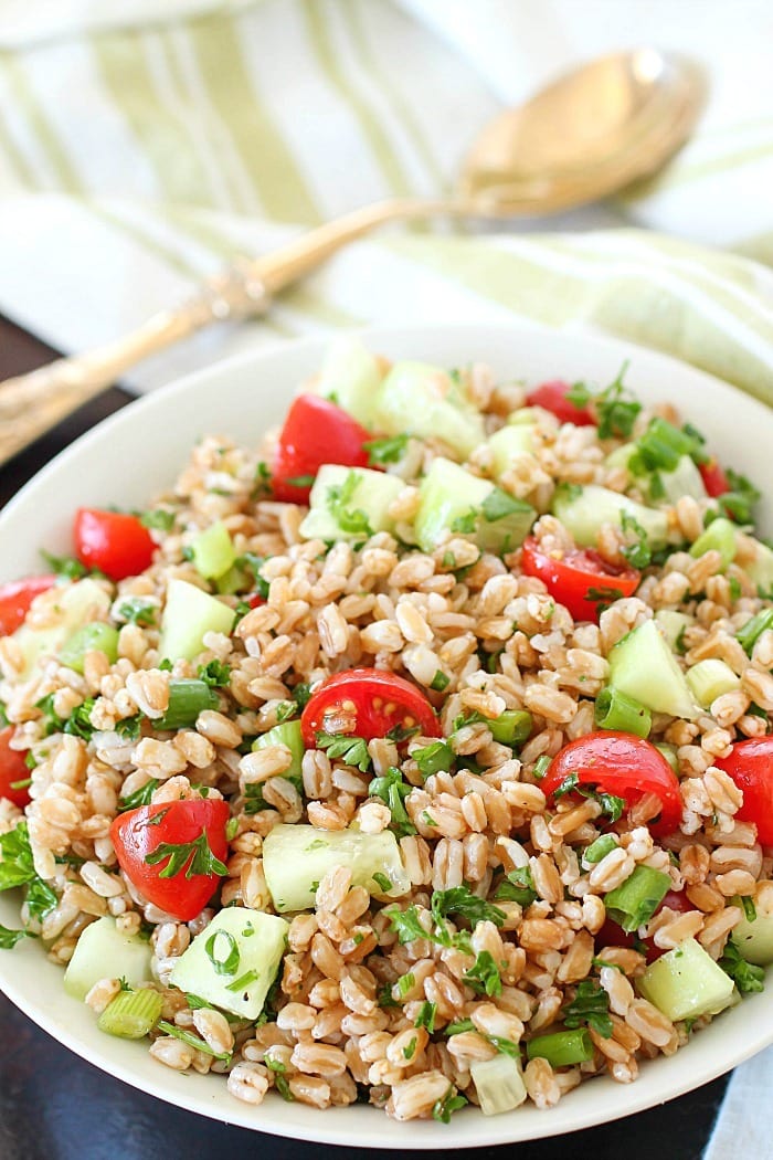 Farro Salad full of tender farro, tomatoes, cucumber, green onions, parsley, and tossed in an olive oil & lemon dressing. Super easy and delicious side dish! With a delicious mix of flavors and textures - I will be making this farro salad again and again and again. :)