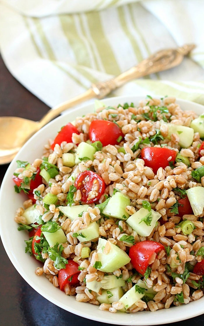 Farro Salad full of tender farro, tomatoes, cucumber, green onions, parsley, and tossed in an olive oil & lemon dressing. Super easy and delicious side dish! With a delicious mix of flavors and textures - I will be making this farro salad again and again and again. :)