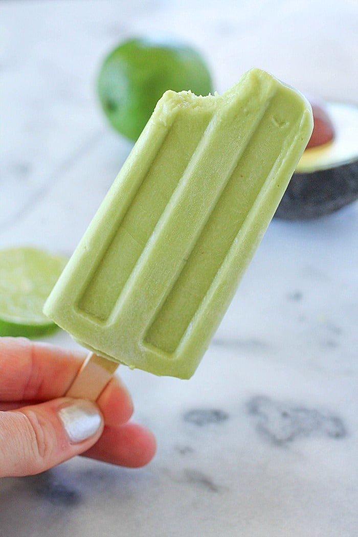 Creamy Avocado Coconut Popsicles - every bite is a tropical getaway! Who would have thought that avocado in a popsicle would be so delicious? You get a little coconut, lime and avocado in every bite of these popsicles! AD