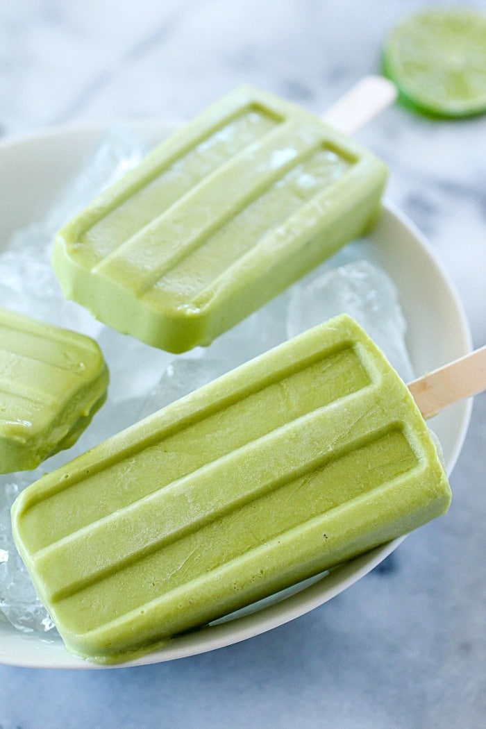 Creamy Avocado Coconut Popsicles - every bite is a tropical getaway! Who would have thought that avocado in a popsicle would be so delicious? You get a little coconut, lime and avocado in every bite of these popsicles! AD