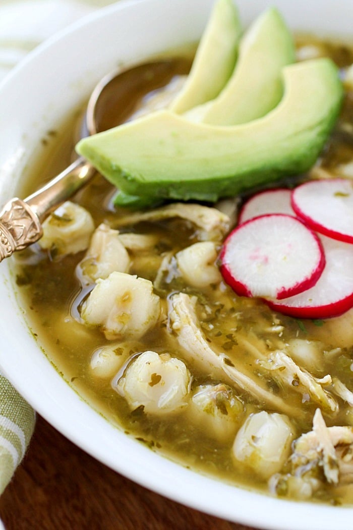 This Chicken Posole Verde Recipe has shredded chicken and tender hominy in a crazy flavorful verde broth! Such wonderful flavor in the verde sauce, you won't even believe it! This soup is best served with radishes, cilantro, avocado, queso fresco and/or tortilla chips. (Skip the chips to keep this gluten free!) AD
