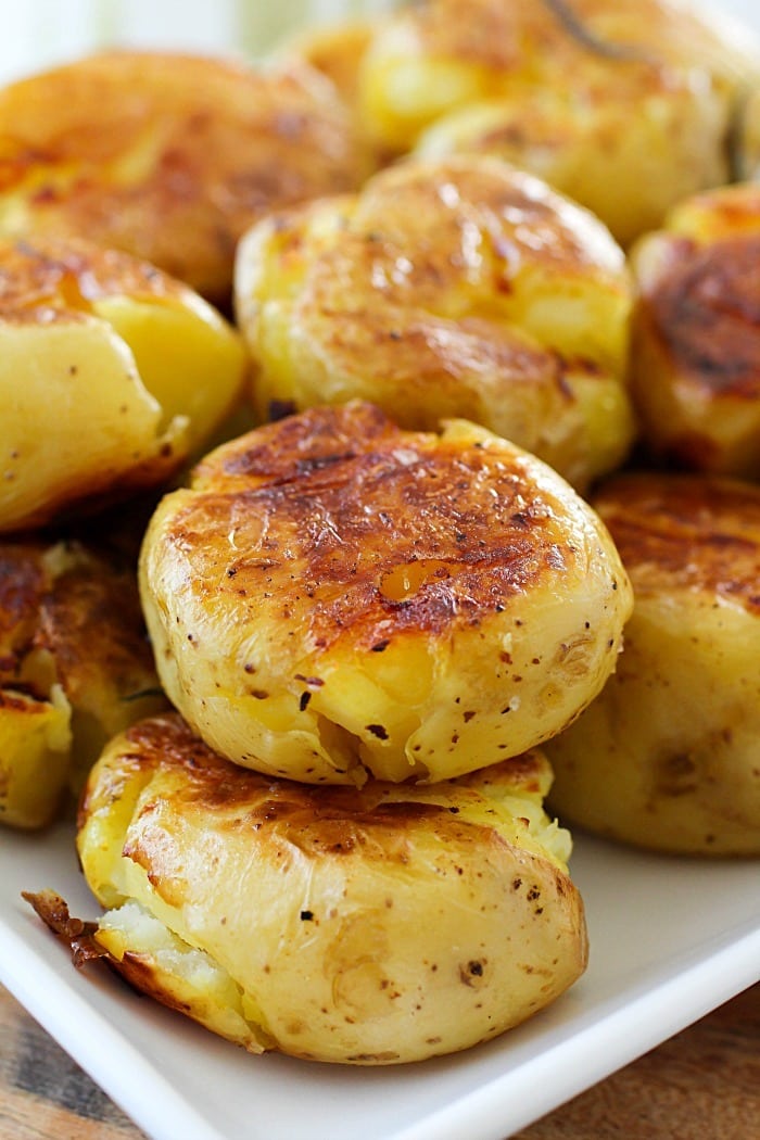 Smashed Potatoes (also known as Potatoes Fondantes) are seriously the best potatoes you will ever eat!! They're boiled in chicken stock and rosemary until tender and then smashed down and browned on each side. Crispy on the outside, tender and flavorful on the inside! Definitely a must-make side dish! AD