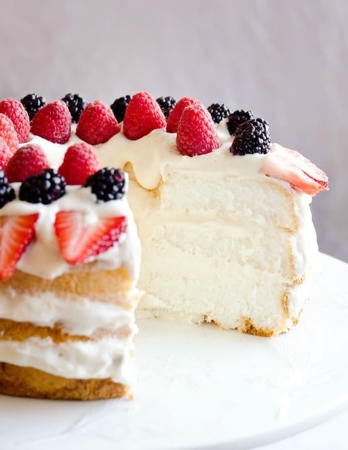 Light Berry Angel Food Cake is an easy and delicious 15 minute dessert with only 5 ingredients. Angel food cake is layered with a luscious white chocolate and coconut Cool Whip layer and topped with fresh berries for a guilt-free low fat treat!