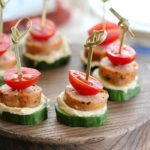 Low Carb Sausage Cucumber Bites skewered with toothpicks on top of a cutting board + 43 Healthy Snack Ideas