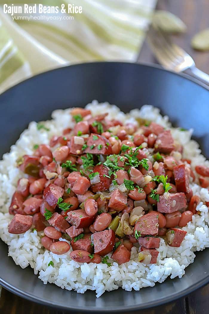 This Cajun Red Beans & Rice Recipe has a delicious little spicy kick to them. Slow cook in a cast iron skillet and then serve over rice for a delicious dinner recipe!
