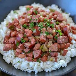 Spice your dinner up tonight and make this Cajun Red Beans and Rice Recipe! Slow cook beans, ham, turkey sausage and spices in a skillet to let the flavors combine. Serve over rice for a delicious dinner the whole family will fall in love with!