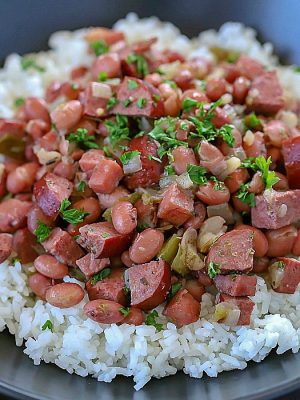 Spice your dinner up tonight and make this Cajun Red Beans and Rice Recipe! Slow cook beans, ham, turkey sausage and spices in a skillet to let the flavors combine. Serve over rice for a delicious dinner the whole family will fall in love with!