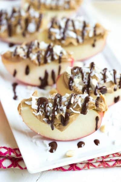 A plate of apple slices drizzled with chocolate and peanut butter + 43 Healthy Snack Ideas