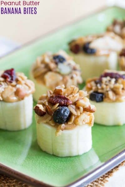 Thick slices of banana topped with peanut butter, berries and granola on a plate + 43 Healthy Snack Ideas