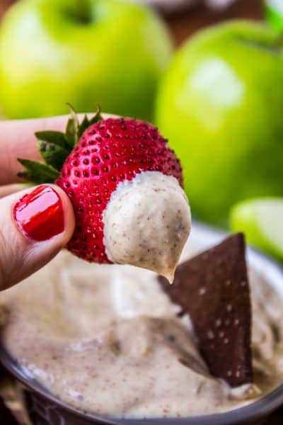 Close up shot of a strawberry that's been dipped into this 2-Ingredient Sugar-Free Fruit Dip Recipe + 43 Healthy Snack Ideas