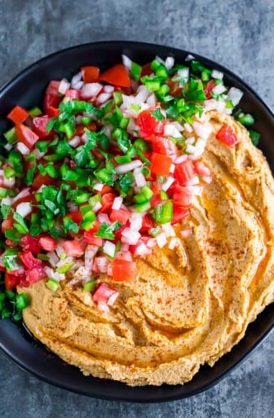Overhead view of a gorgeous orange taco hummus with a spicy pico de gallo + 43 Healthy Snack Ideas
