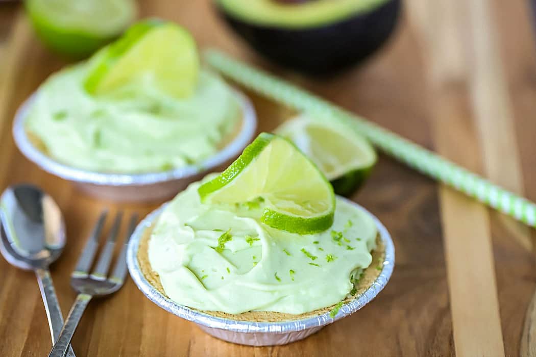 Horizontal photo of two mini key lime pies topped with sliced limes