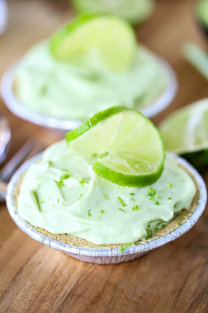 Close up photo of two mini pies topped with limes.