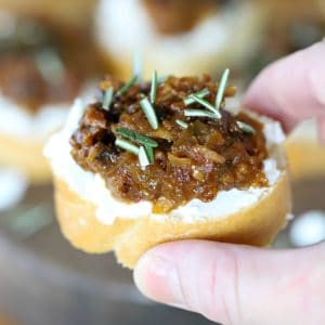 Layered crostini with bacon jam and goat cheese on bread,
