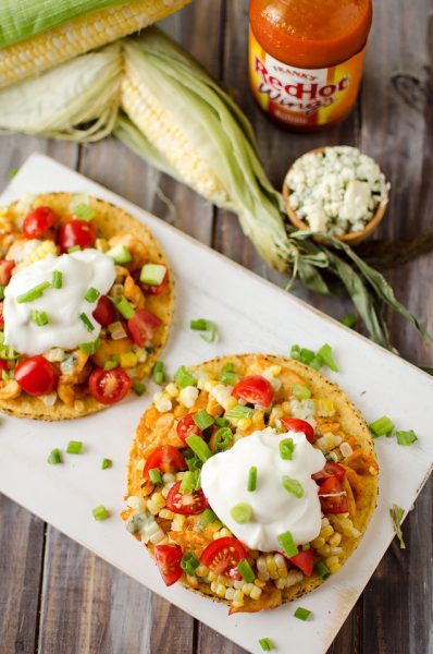 A plate of tostadas topped with corn and sour cream.