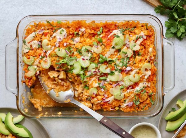 Healthy Cauliflower Casserole in a glass dish with a spoon inside.