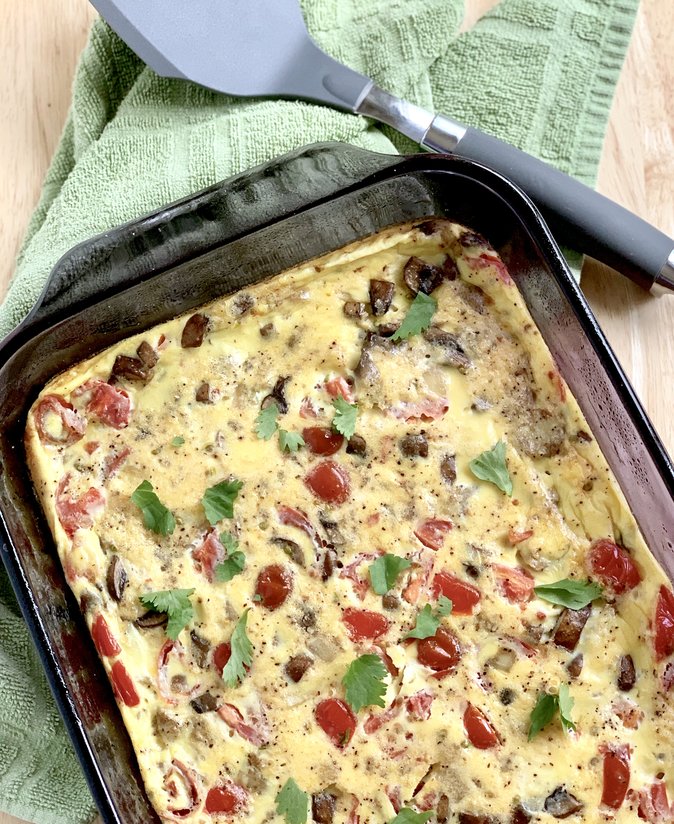 Over the top shot of an egg casserole with a spatula on the side.