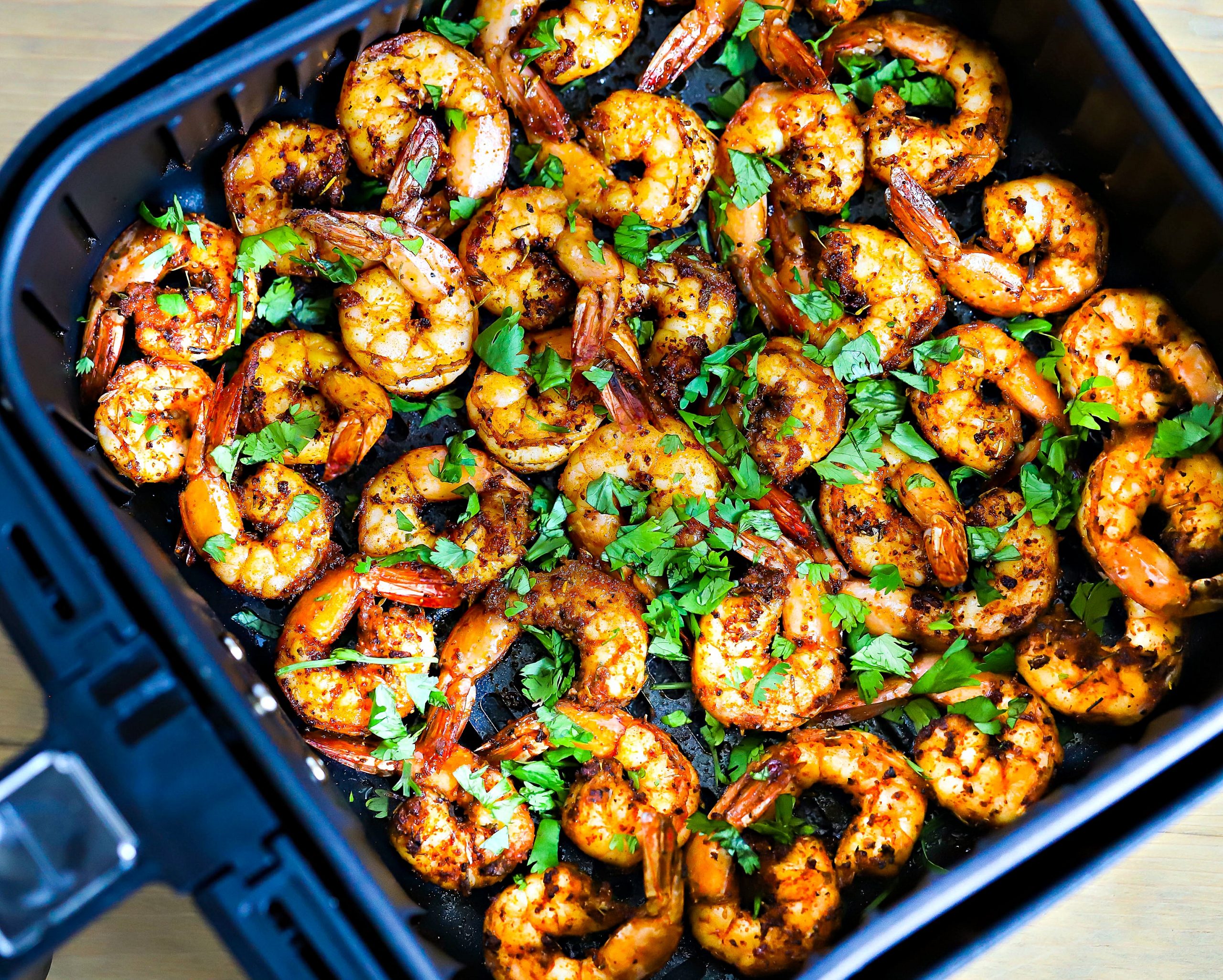 A pile of air fryer shrimp on a white plate.