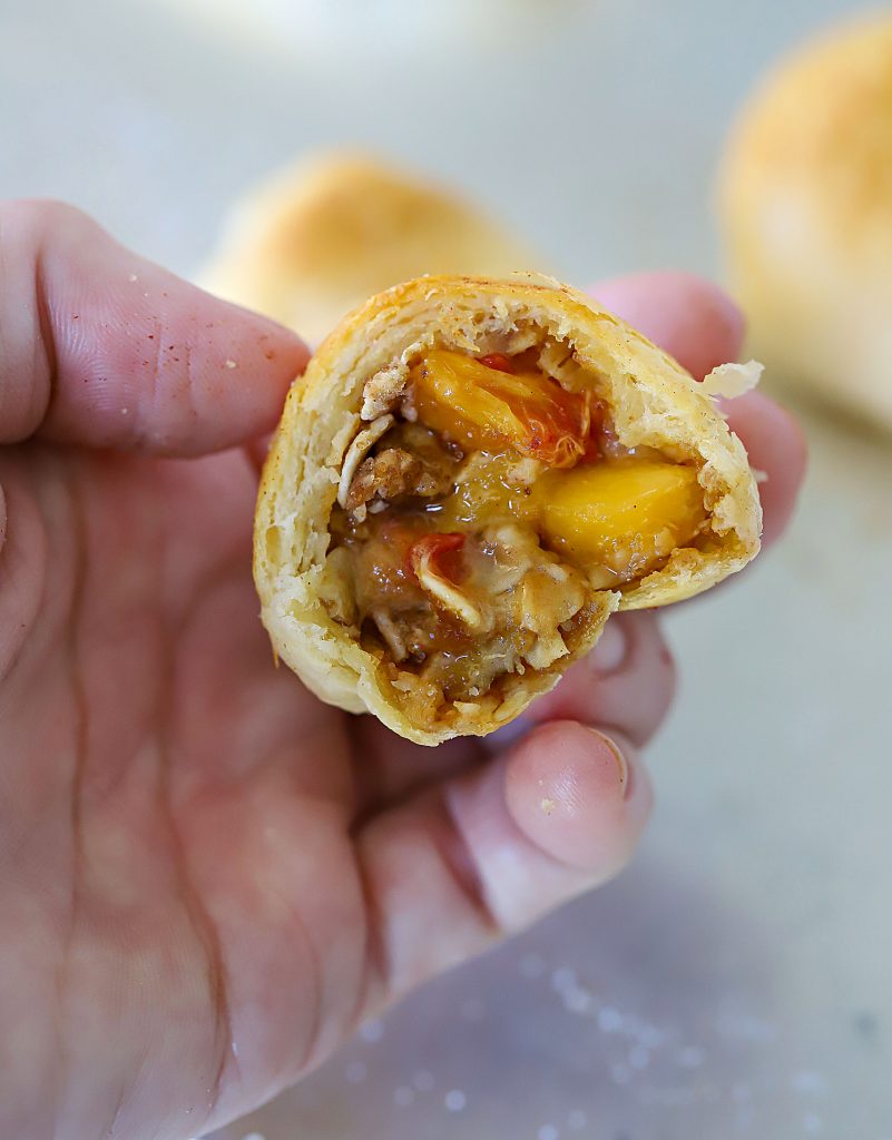 Crescent Roll cut in half showing a peach and crumble filling.