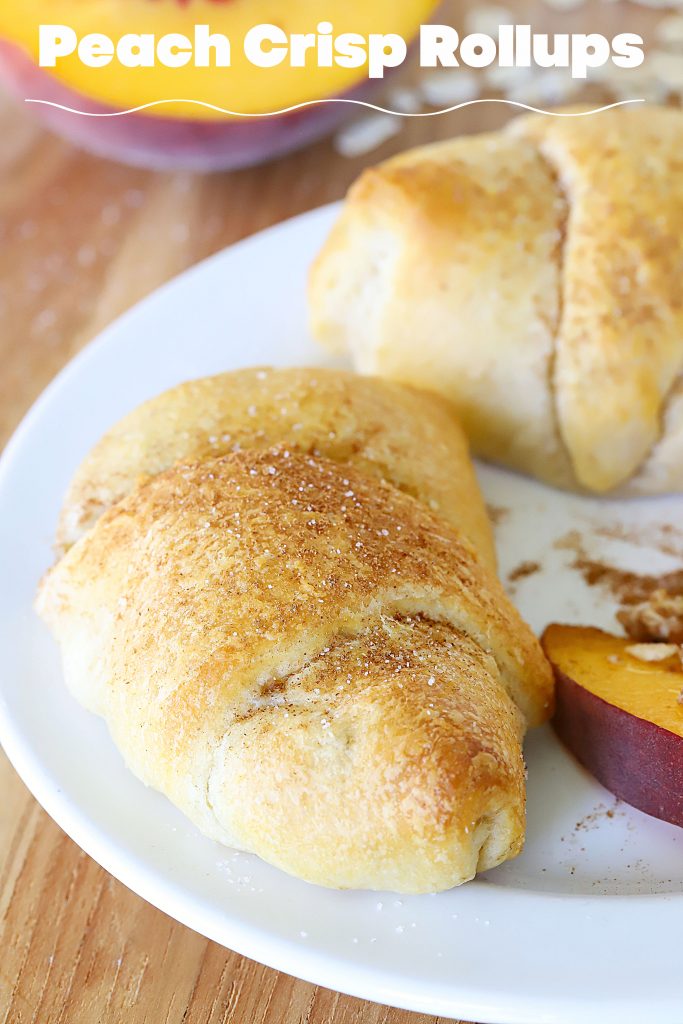 Crescent Roll filled with peaches and a crumble rolled up and sitting on a plate.