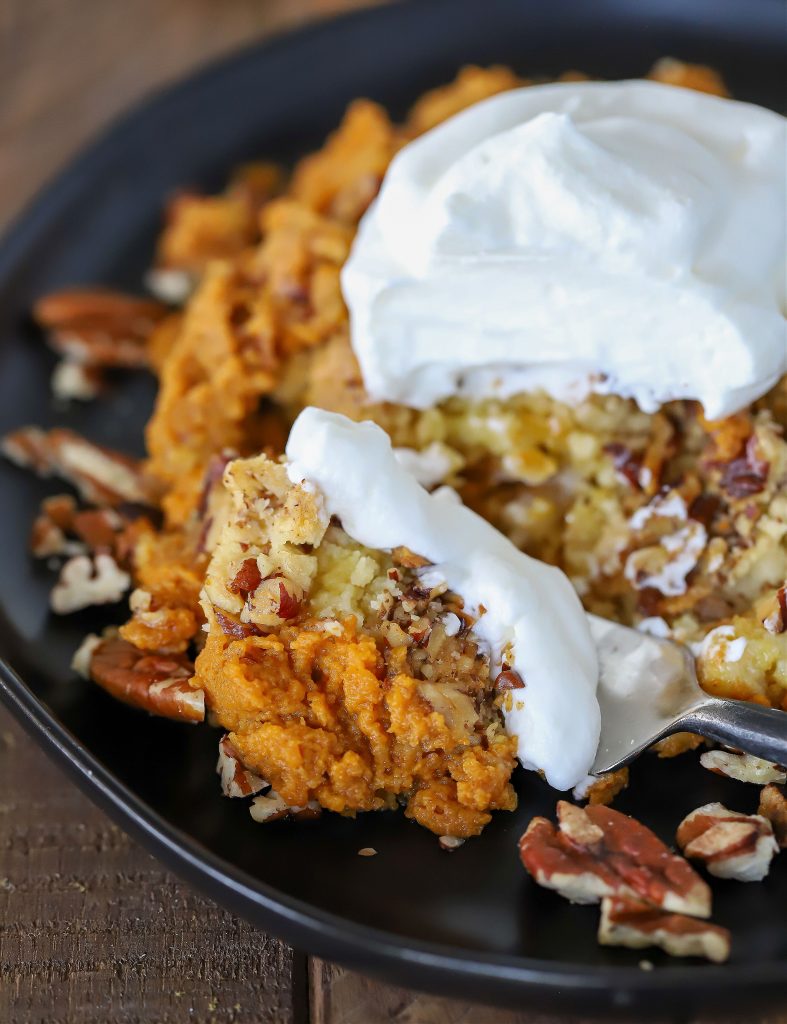 Pumpkin Dump Cake with a scoop of whipped cream on the top.