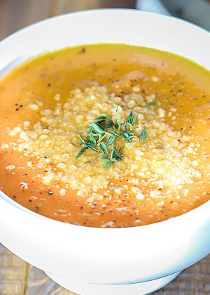 Bowl of soup topped with herbs.