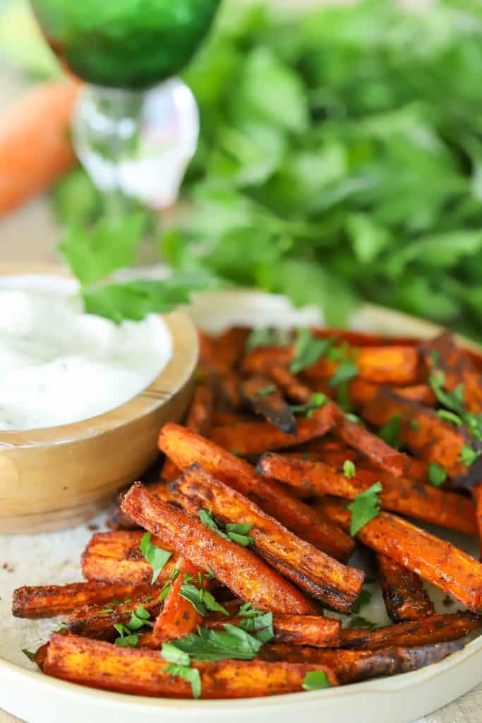 Carrot slices on a plate with dip on the side.